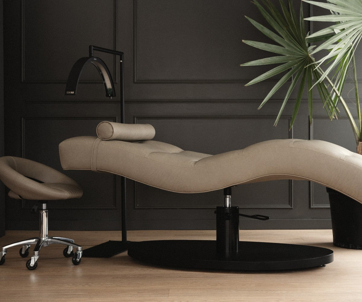 Vera Sleek 360 curved beauty bed against a dark wall